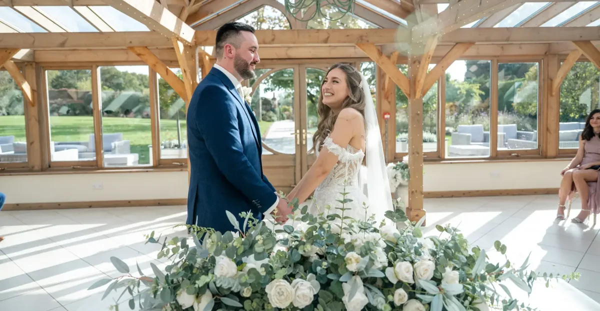 Bride and groom getting married in the Orangery at Gaynes Park